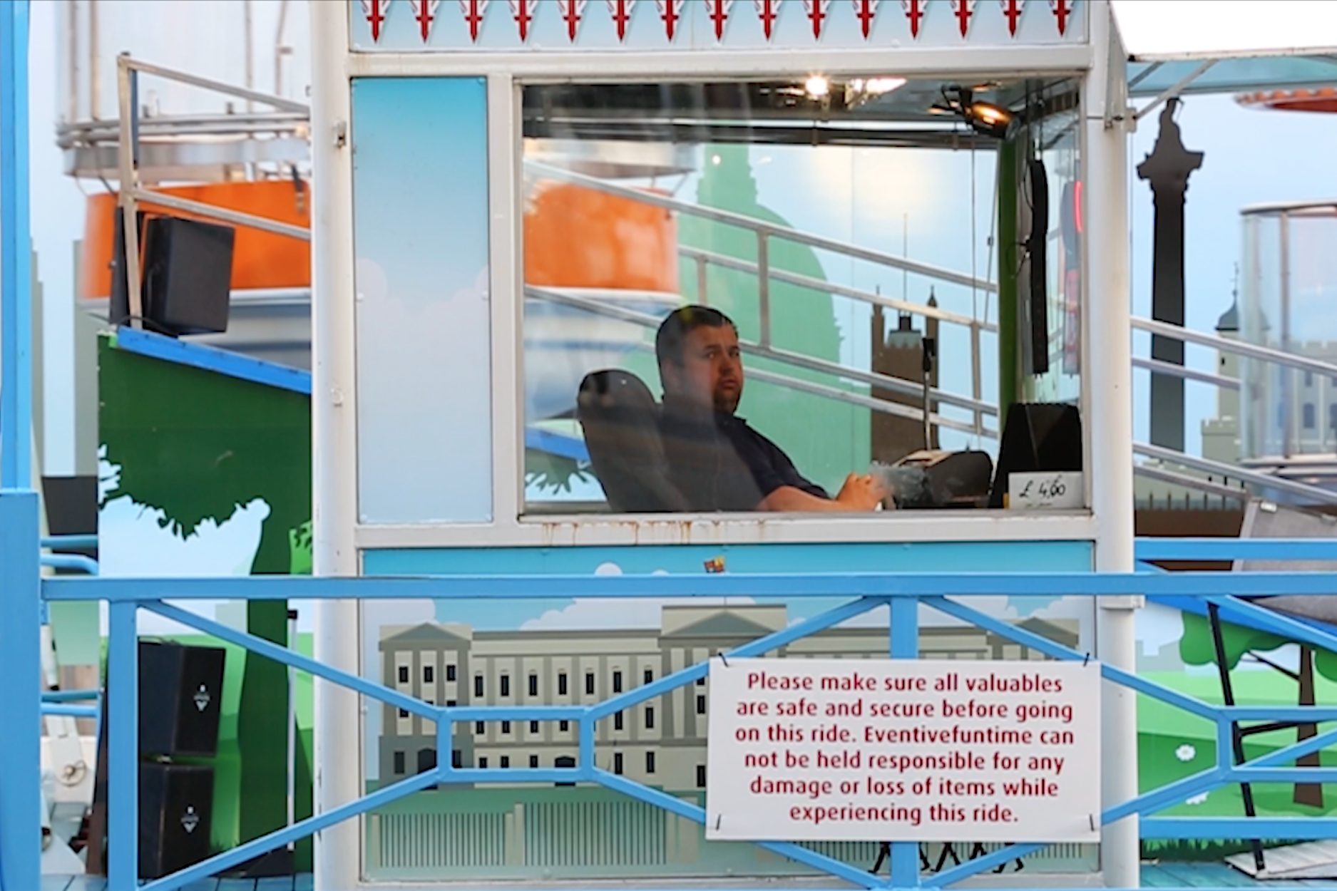 seated man starring from his ticket cabin for a big wheel