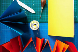 looking down onto coloured paper and tools