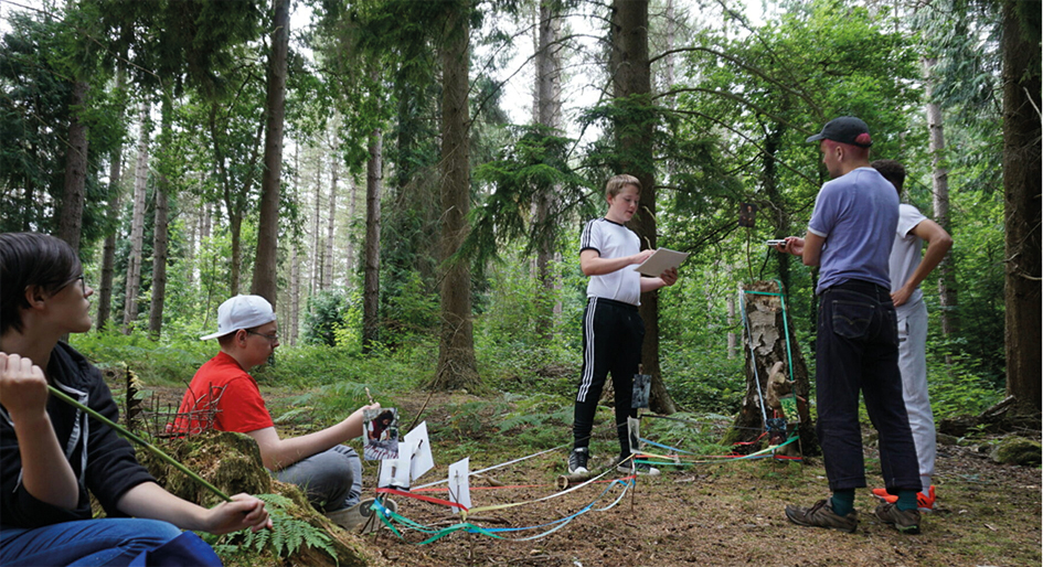 group of youths standing together in a forest